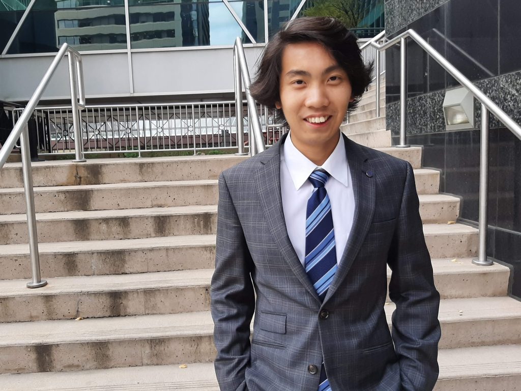 Calgary online marketing consulant Henry Tsang poses in front of an office building